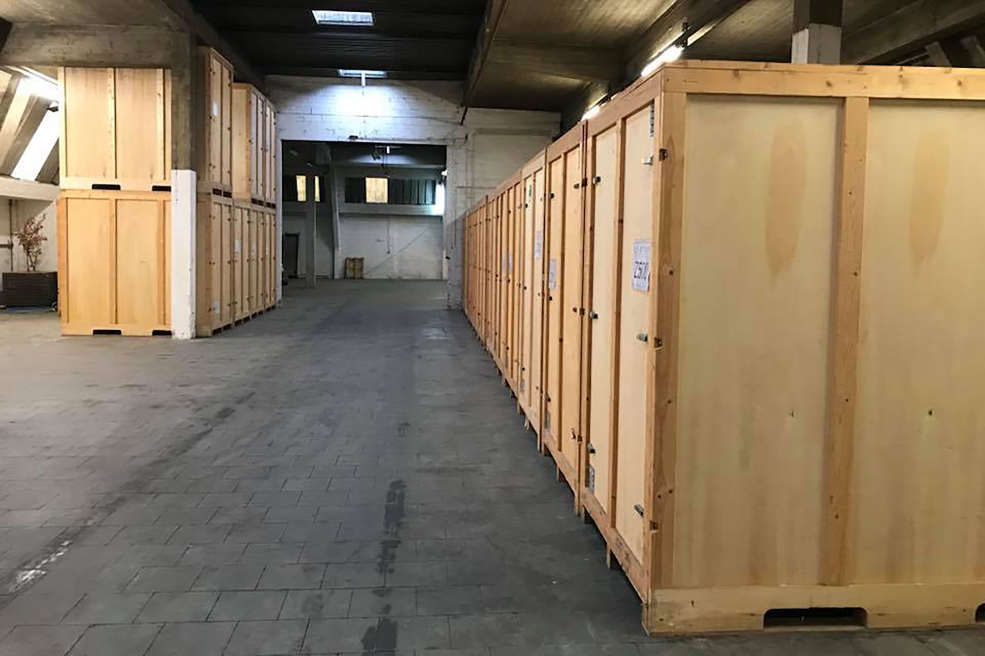 Allée de box de stockage en bois dans l'entrepôt Euro Renting Box à Evere